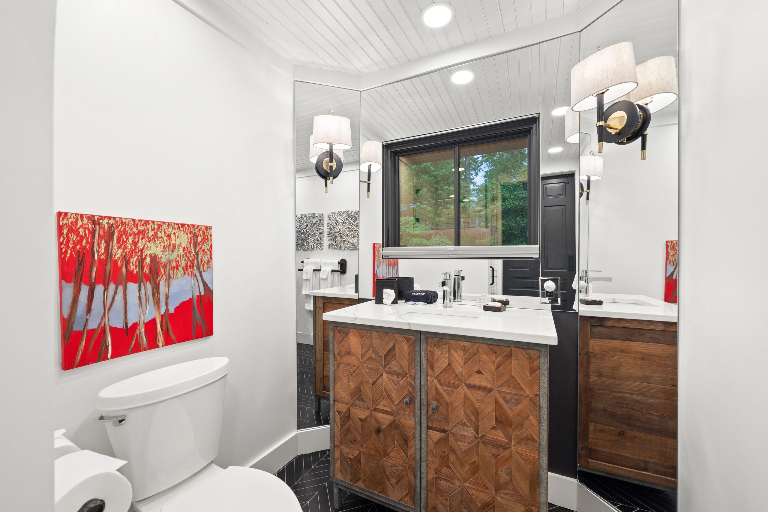 Modern bathroom with wooden cabinet and vibrant red artwork
